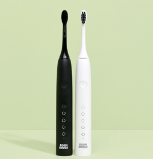 Brosse à dents électrique Boombrush en noir et blanc avec design minimaliste et modes de brossage LED sur fond vert